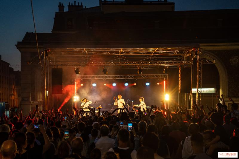 Ambiance de la Fête de la Musique parisienne dans une rue animée avec musiciens